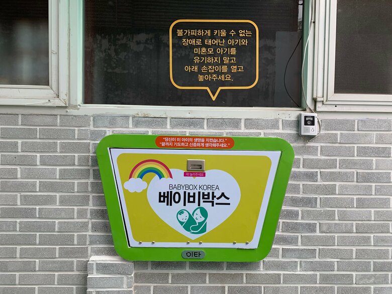 韓国のBaby box。オレンジ色のふき出しには「やむを得ず、子どもの障害や未婚等で子どもを育てられない場合は、子どもを遺棄せずに下の扉を開けて預け入れてください」と書かれている