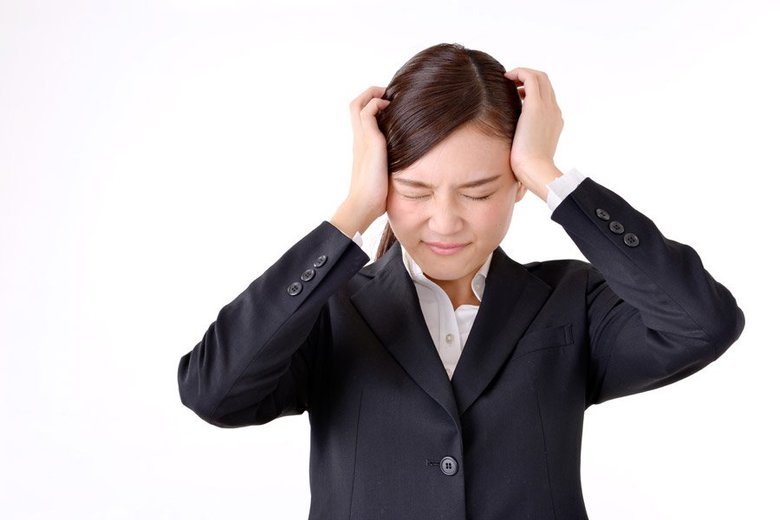 頭を抱えて怒る女性の画像