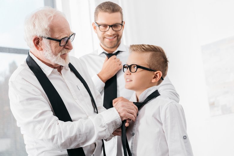 grandfather helping grandson with tie