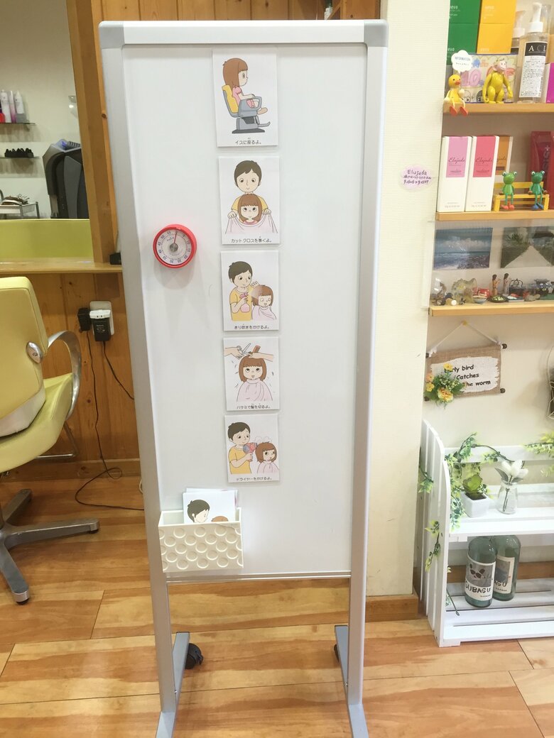 美容室に置かれた時計とイラスト。いつ散髪が終わるか、子どもたちが想像できるように工夫を重ねた