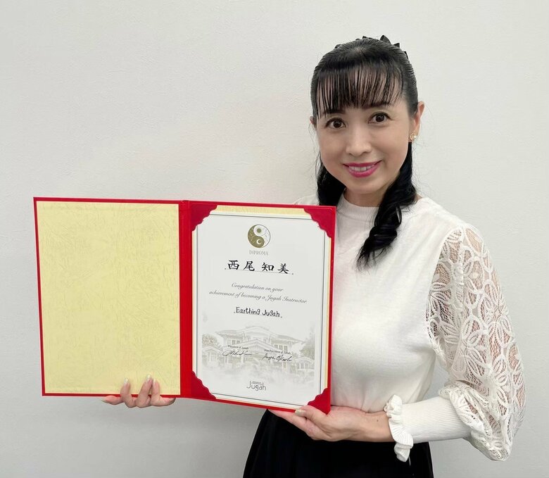 アーシングジュガの合格証明書を持つ西村さん