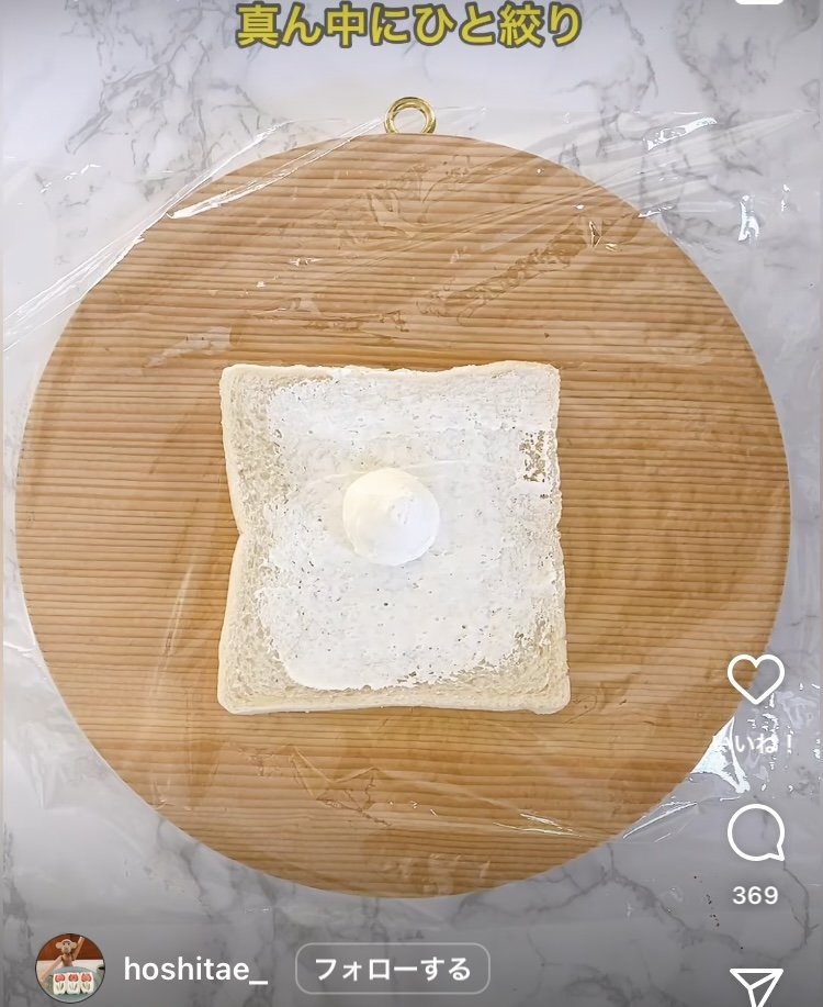 【作り方8】まな板にラップを敷き、8枚切りの食パンを置いてホイップクリームを塗る。中央にホイップをひと搾りする