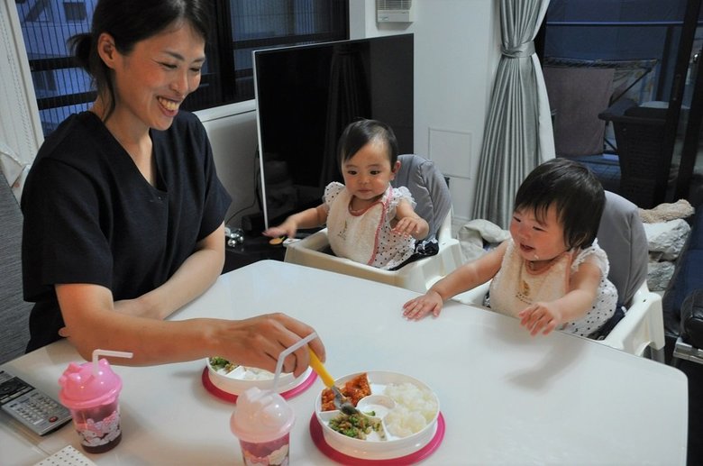 双子に夕食を食べさせる茜さん。1人を抱っこしながらもう1人に食べさせることもある