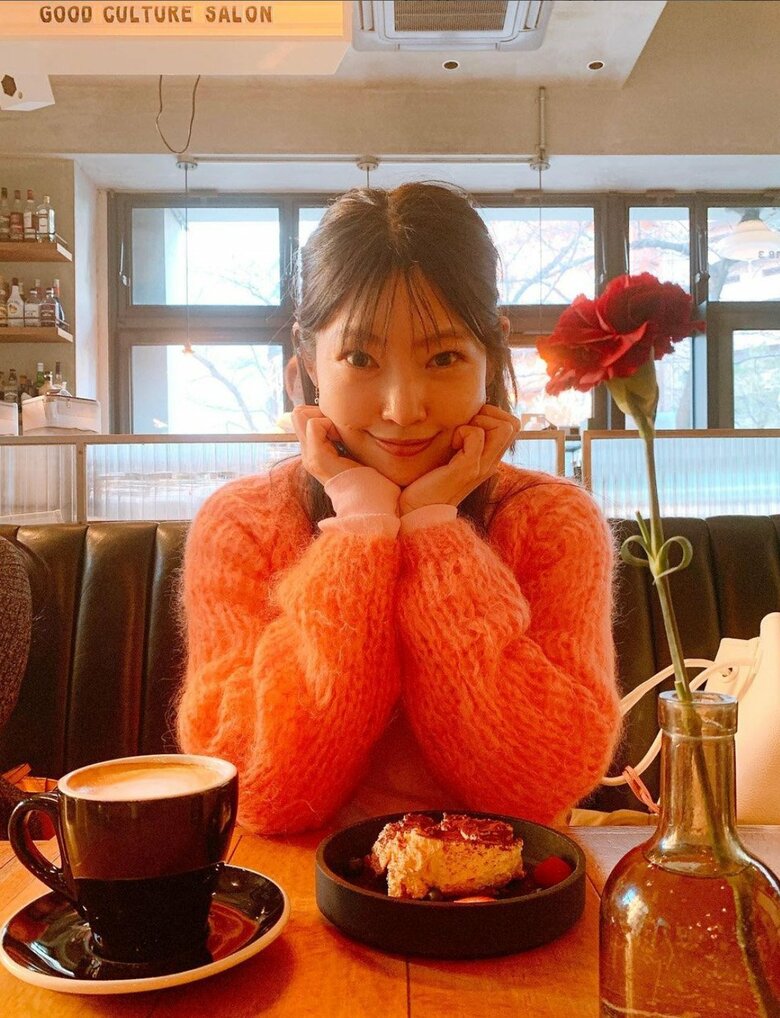 どんな色も着こなします！オレンジのニットで頬杖ショット