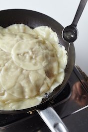 ふたをとり、フライパンの水けを完全に飛ばす。鍋肌からサラダ油大さじ１/２を加え、フライパンをゆすりながらカリッとした焼き目をつける。