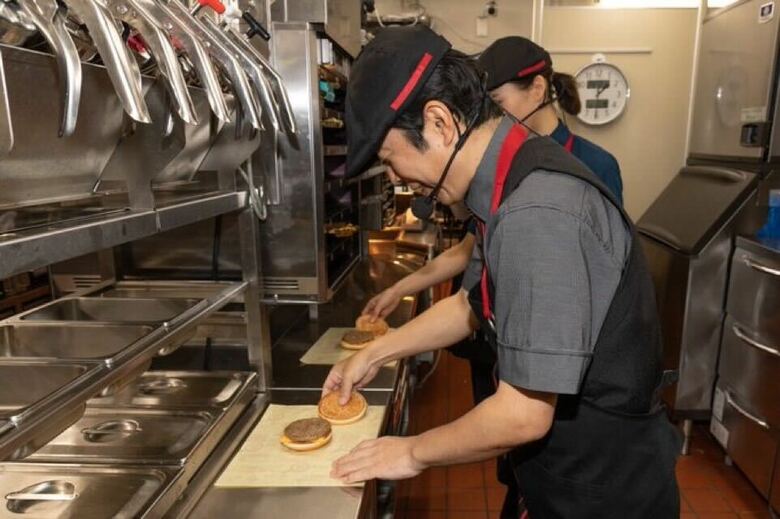 マクドナルドのクルー体験会に参加するダンディさん。ハンバーガーを作る手つきもさすがです