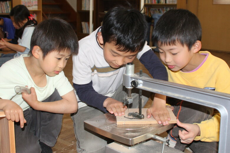 体験学習で糸のこを使う子どもたち