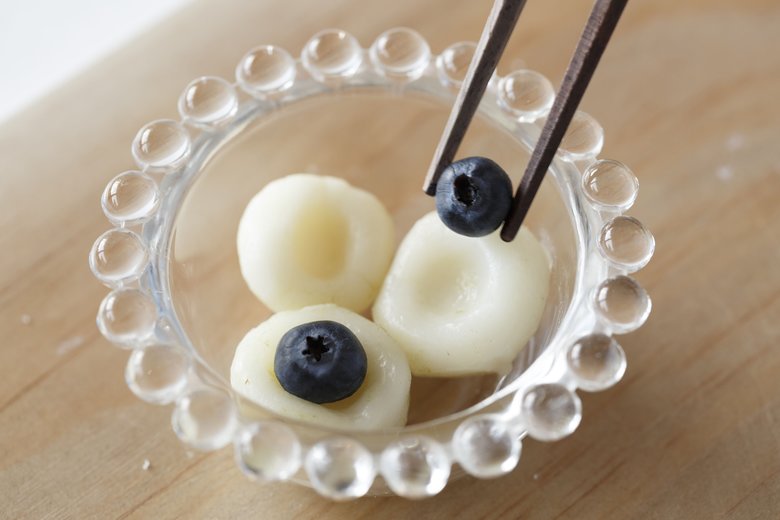 白玉粉に分量通りに水を加えてよく練って丸めて白玉だんごにする。それぞれ小指で真ん中に凹みをつける。たっぷりのお湯でゆでて、よく冷やす。写真下のように凹みにブ ルーベリーをのせれば、でき上がり。「ブルー ベリーのヘタがあるほうを上にすると目玉感がいっそうUPします」。抹茶シロップやあんこ、生クリームを合わせて和風スイーツにすると、おいしい。