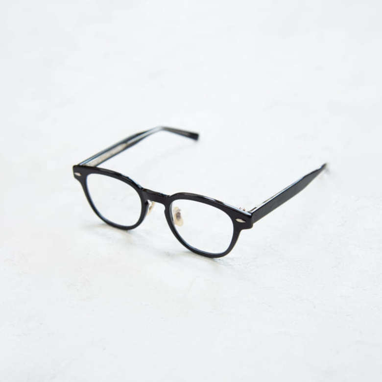 「アイヴァン」の黒ふちメガネ。「曇りのないレンズのツヤは、顔まわりをスッキリと見せ、清潔感も感じられます」（山本さん）