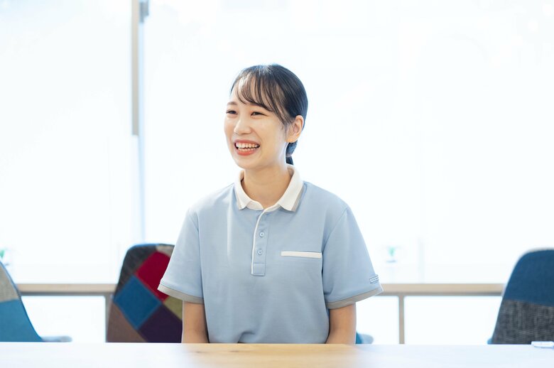 爽やかな水色の制服で取材に応じる村山さん。可愛らしい笑顔が魅力的