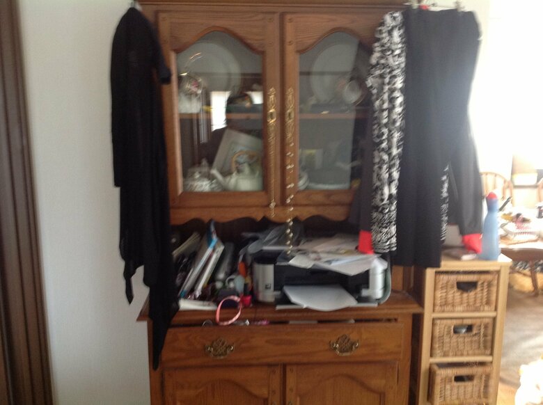 「入るだけ入っていた」大きな食器棚。外には洋服がハンガーで吊るされ、隙間には雪崩が起きそうなモノの山が