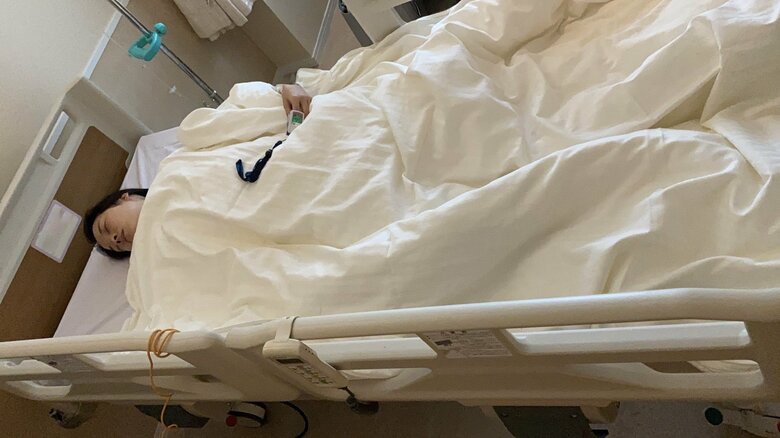 流産後の手術をした際に、病院のベッドで横になる奈津子さん