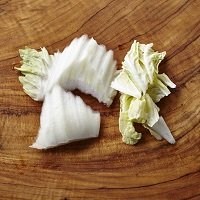 白菜は、白い部分はひと口大のそぎ切り、緑色の葉はざく切りにする。にんにくは半分に切って芯を除き、つぶす。エリンギは長さを半分にし、薄切りにする。鶏肉はひと口大に切る。