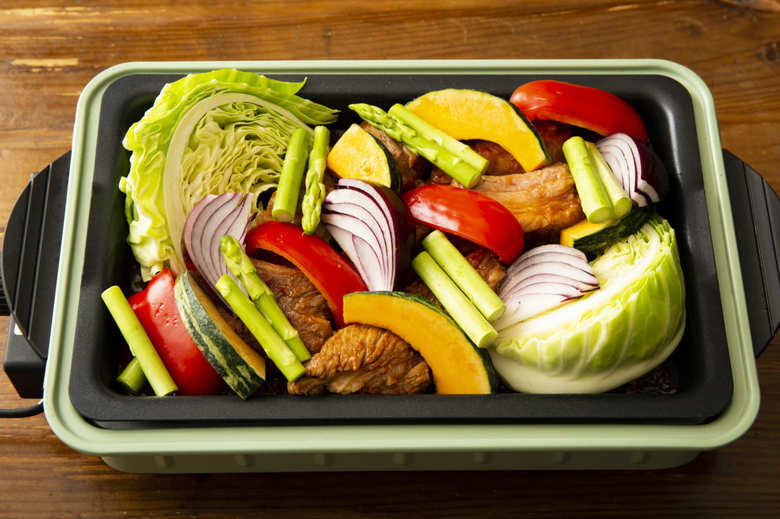 ホットプレートにオリーブオイル大さじ1/2を入れて高温にし、①を入れて両面を焼く。表面の色が変わったら真ん中に寄せ、両端にキャベツをおく。肉の上にレモン以外の切った野菜をバランスよく並べ、全体に塩・こしょうをしっかりめにふり、オリーブオイルをかける。ふたをして中温にし、15分ほど加熱する。肉に火が通ったらレモンを添える。