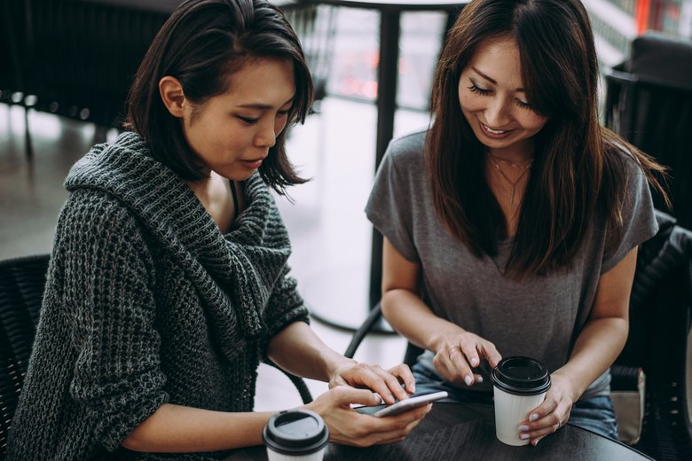 Two japanese women around in Tokyo during daytime. Making shopping and having fun