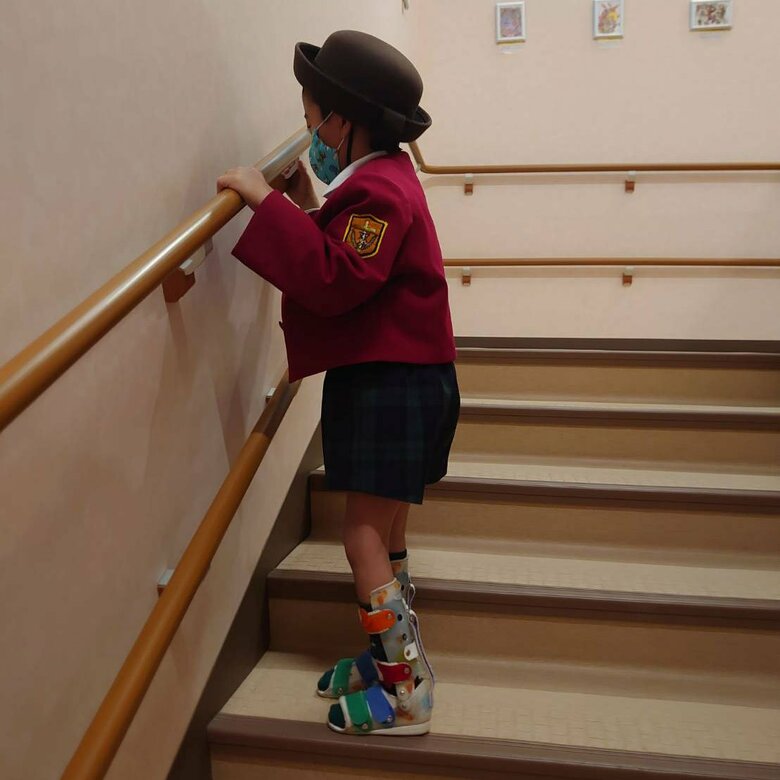 幼稚園の手すりを使って階段をのぼる息子