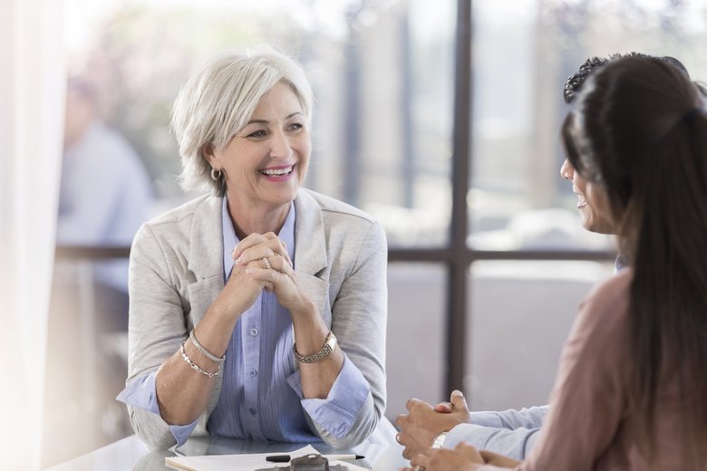 Senior female executive smiles during corporate briefing