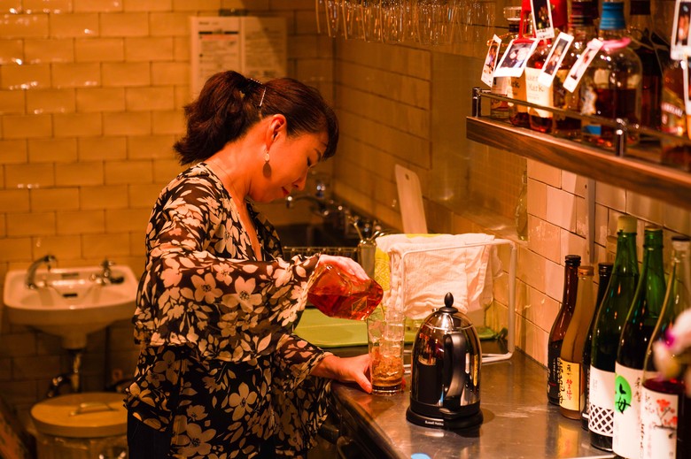 お店のカウンターでお酒を作る紫乃ママ