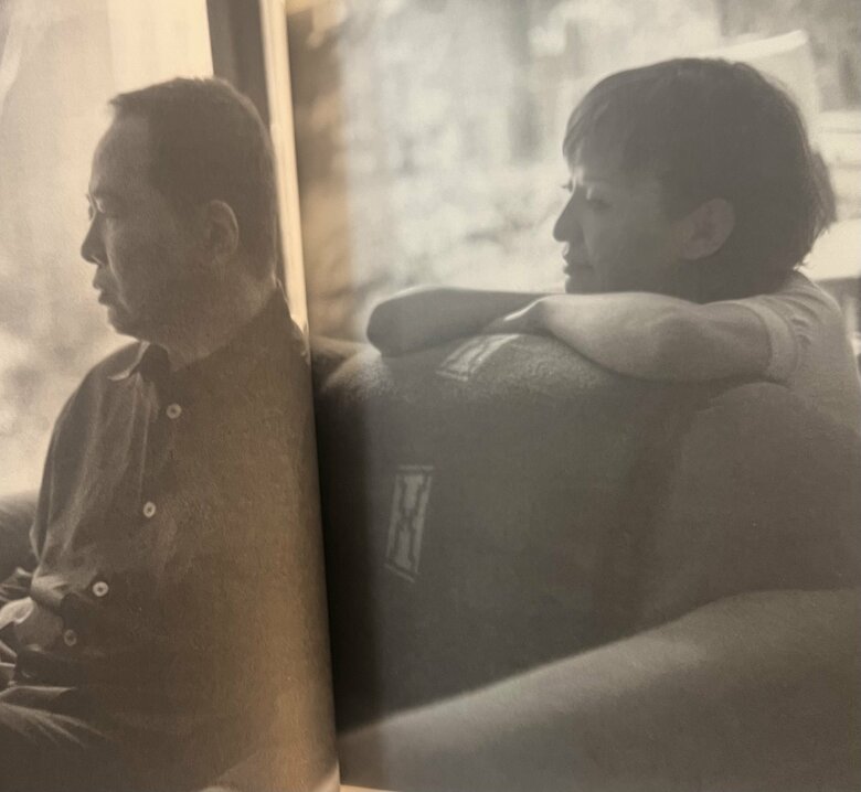 自宅リビングで根津甚八さんがお気に入りのソファに座って仁香さんが見守る温かな様子