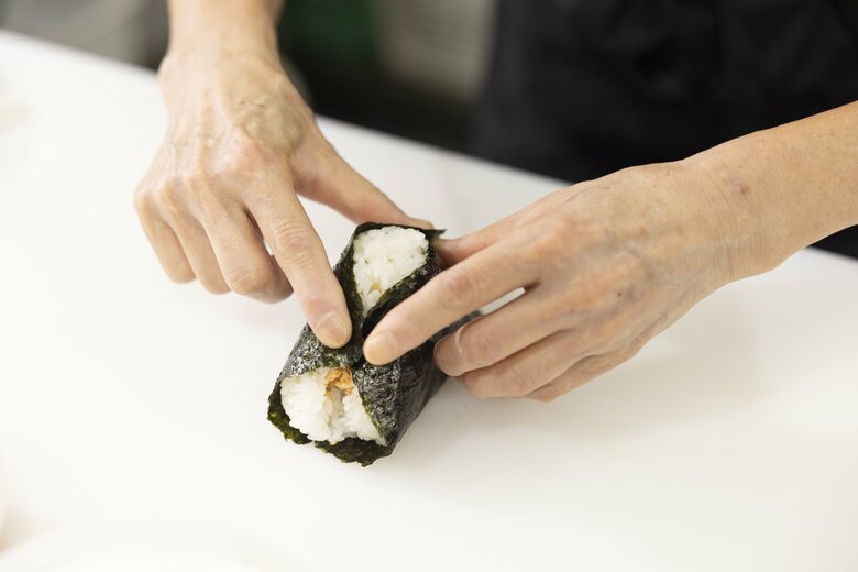 15／海苔を両側にかぶせ、人差し指と親指でおにぎりの先にくっつける
