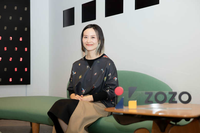 「見た目は違ってもみんな一緒」という想いが込められたZOZOのロゴの隣で想いを語る篠田さん。