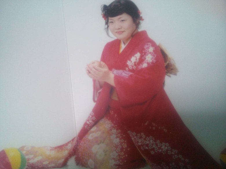 成人式で鮮やかな赤の着物を着たオカリナさん。やや緊張した面持ち