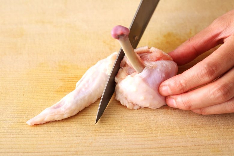 手羽先の先端部分を切り落とし、肉の形を整える。