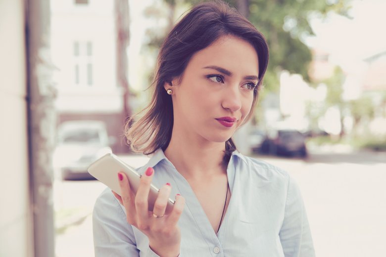 スマホを持ってふくれっ面する女性