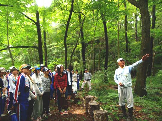 高校生に雑木林について説明する公園ボランティア。人を繋ぐことも仕事