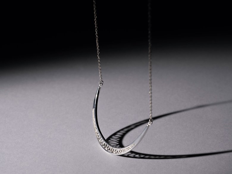 レースのような影ができる「TOUROU」のネックレス「crescent moon – necklace」