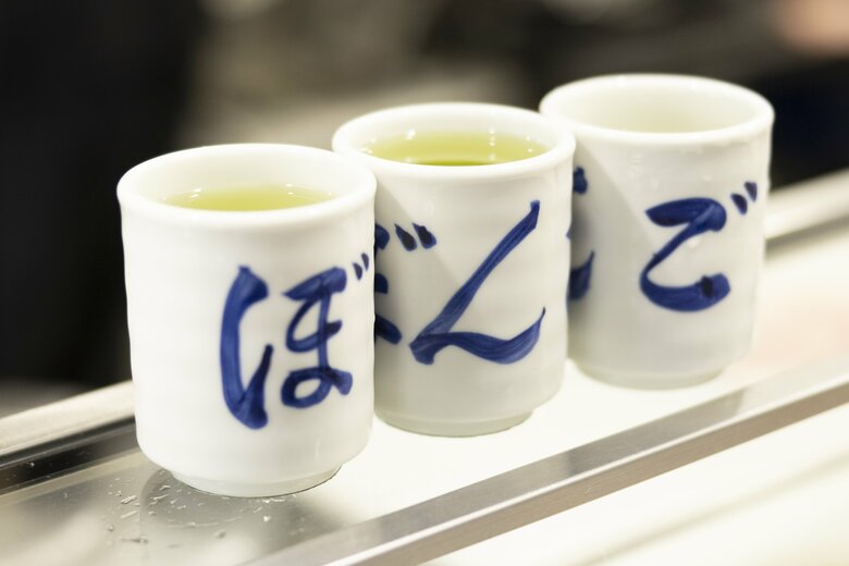 行列に並ぶ店外のお客様のためにスタッフが冷たいお茶を配る