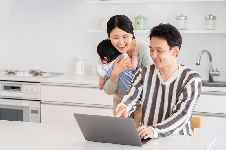 young asian family using laptop in kitchen