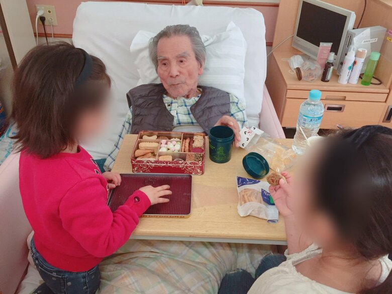 おやつを一緒に食べる義父と子どもたち