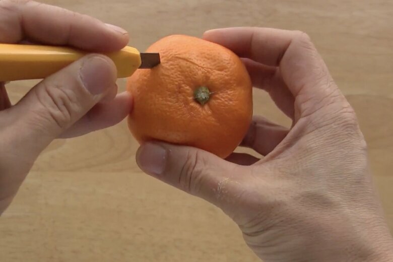 みかんにカッターで切り込みを入れていく（1/4）