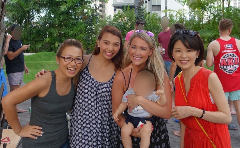 色鮮やかなワンピース姿が自然に映える中野さん（写真右）。シンガポールで出会った友人たちと笑顔弾けるショット
