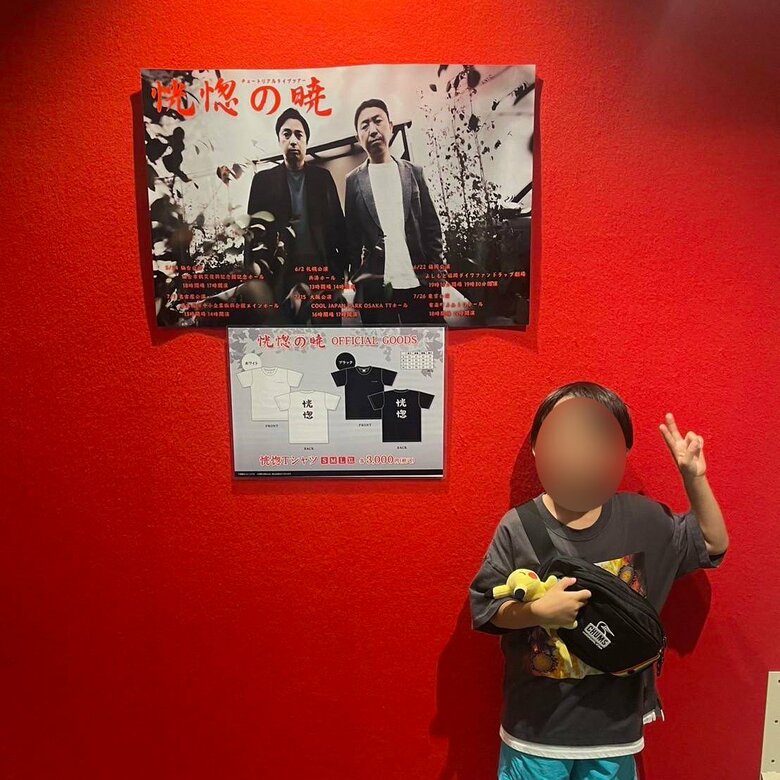 父親のポスターと並ぶ息子さん