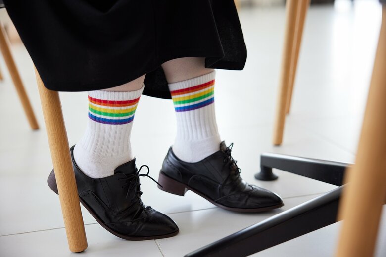 坪井さんは、全国の店舗で販売されたレインボーカラーデザインの靴下を履いて取材に応じてくれた