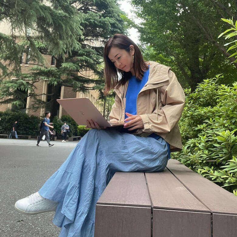 「鮮やかなブルーのニットがお似合い」大学構内でパソコンを開く宮崎さん