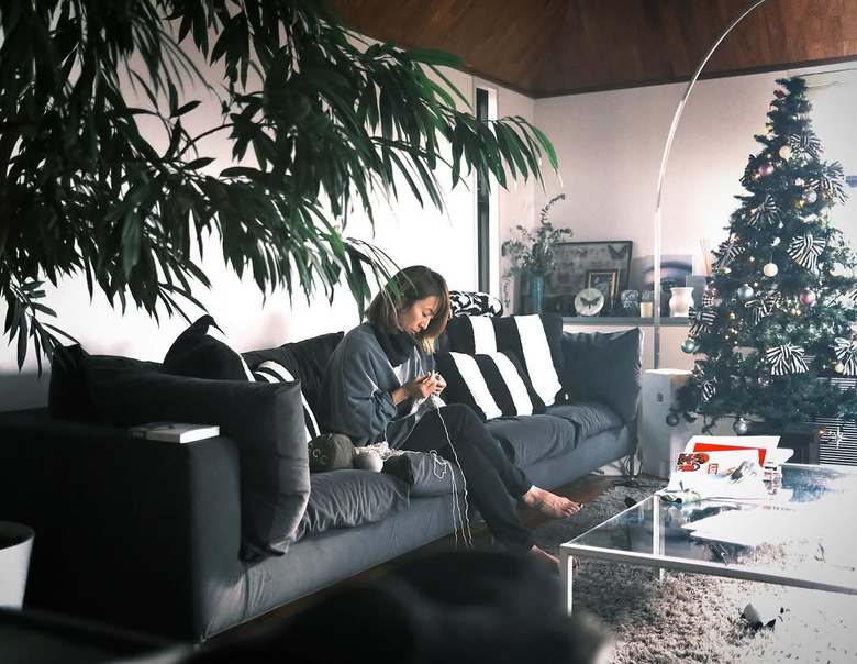 家族のセーターを編んでいる妻