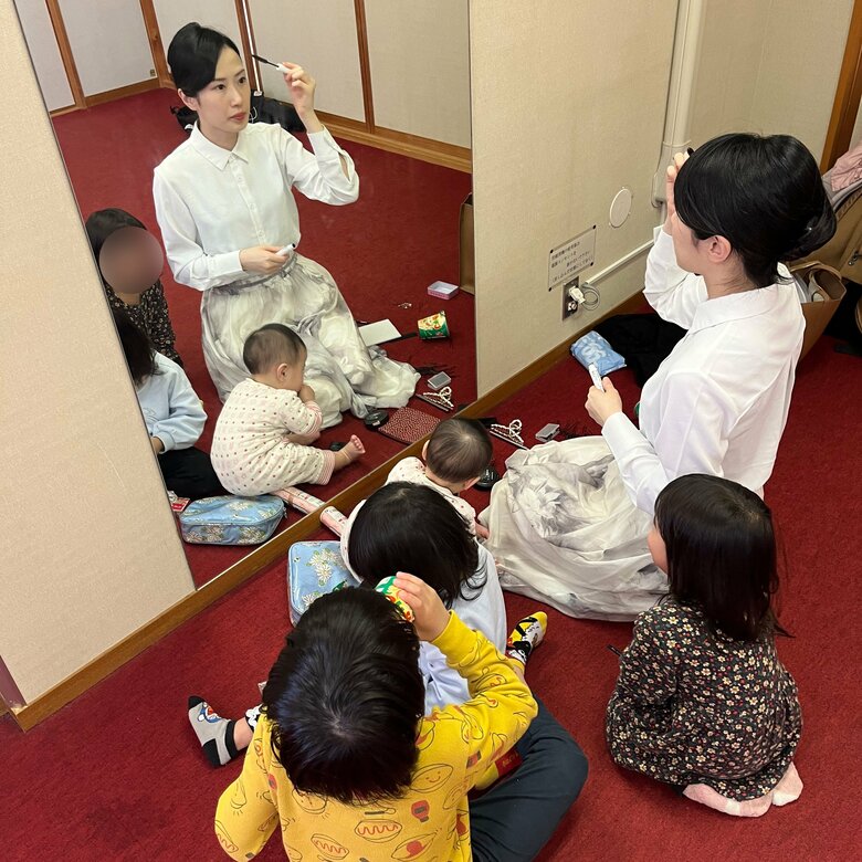 メイク中の七代目一龍斎貞鏡さんを取り囲む4人の子どもたち