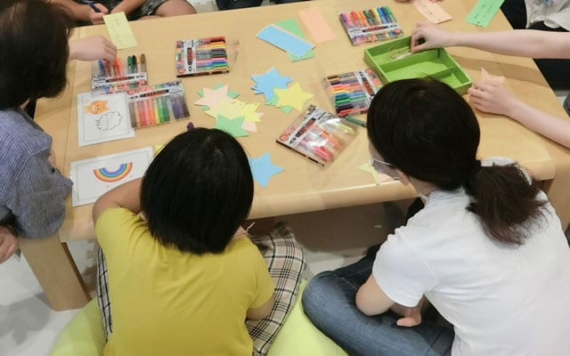 七夕飾りに願いごとを書く子供達