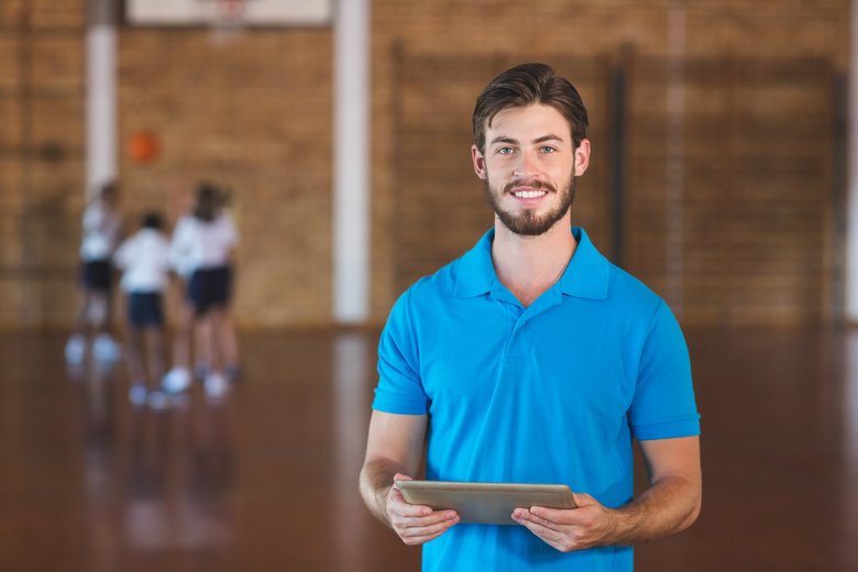 Portrait of sports teacher using digital tablet