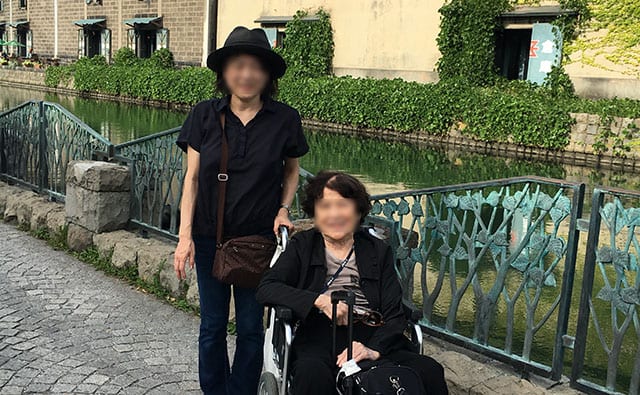 車椅子の母と介護する娘