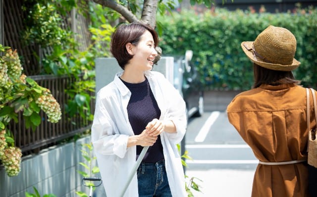 ご近所さんと挨拶をする女性