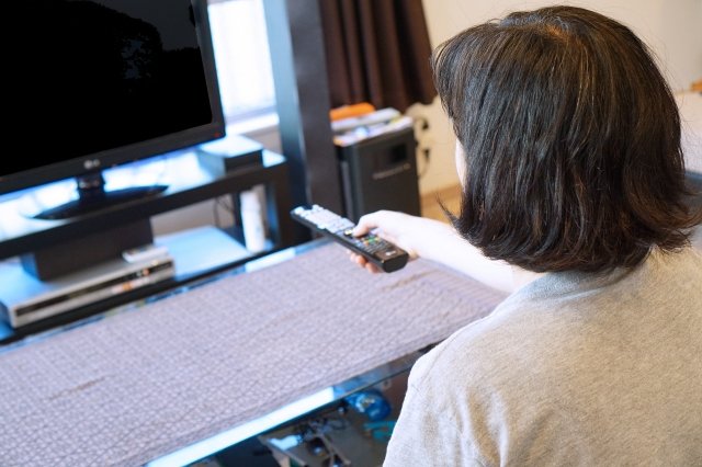 テレビをみながら太ももヤセをする女性の画像