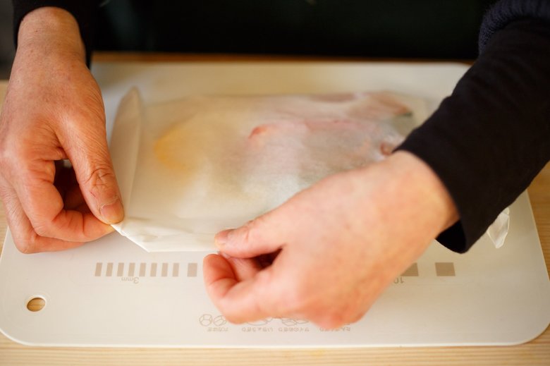 ▲クッキングシートで包む際は、重なった３辺を内側にしっかり折り込み、両角の耳を折る。