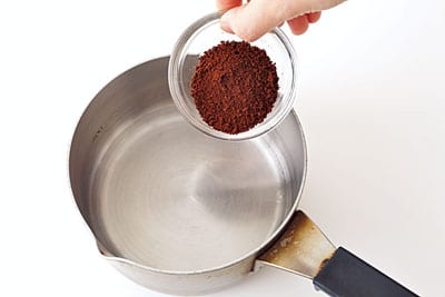 ミネラルウォーター1/4カップ、インスタントコーヒーを小鍋に入れて溶かす。砂糖を加えたら中火にかけ、砂糖を溶かす。
※砂糖を加えたあとは溶けにくくなるので、インスタントコーヒーは先に溶かしておくこと。