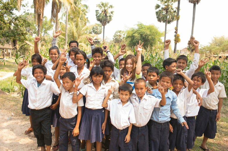 カンボジアの子どもたちに囲まれて満面の笑みの倉木さん