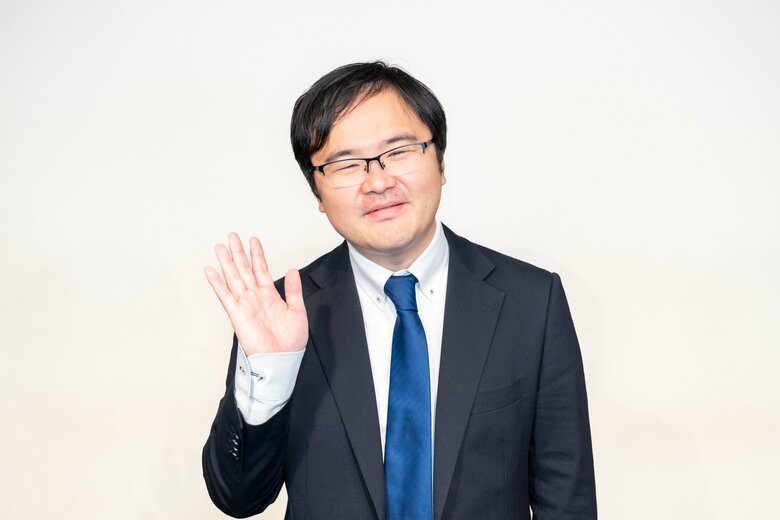 七三分け、スーツにメガネがトレードマーク