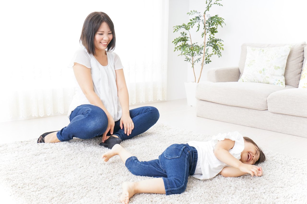 カーペットに寝転ぶ子どもと母親